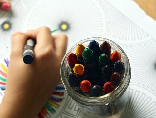 En hånd som tegner med fargestifter 